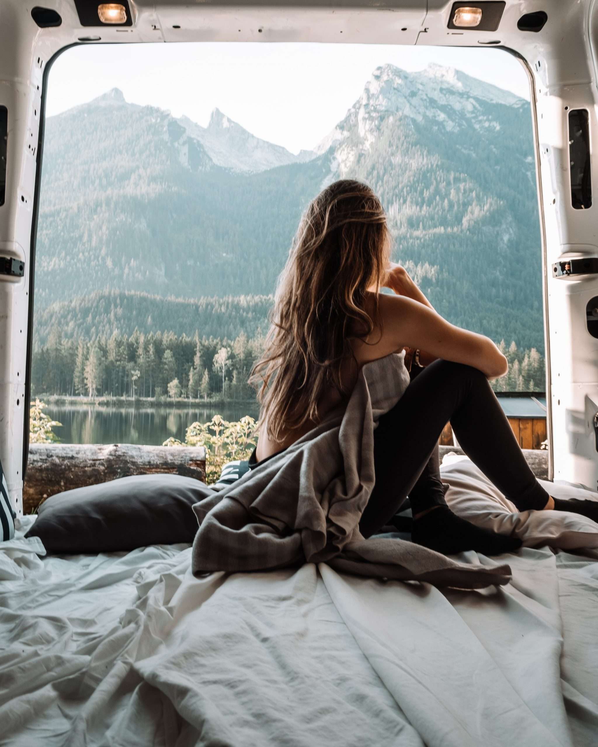woman-in-the-back-of-a-van-looking-at-mountains