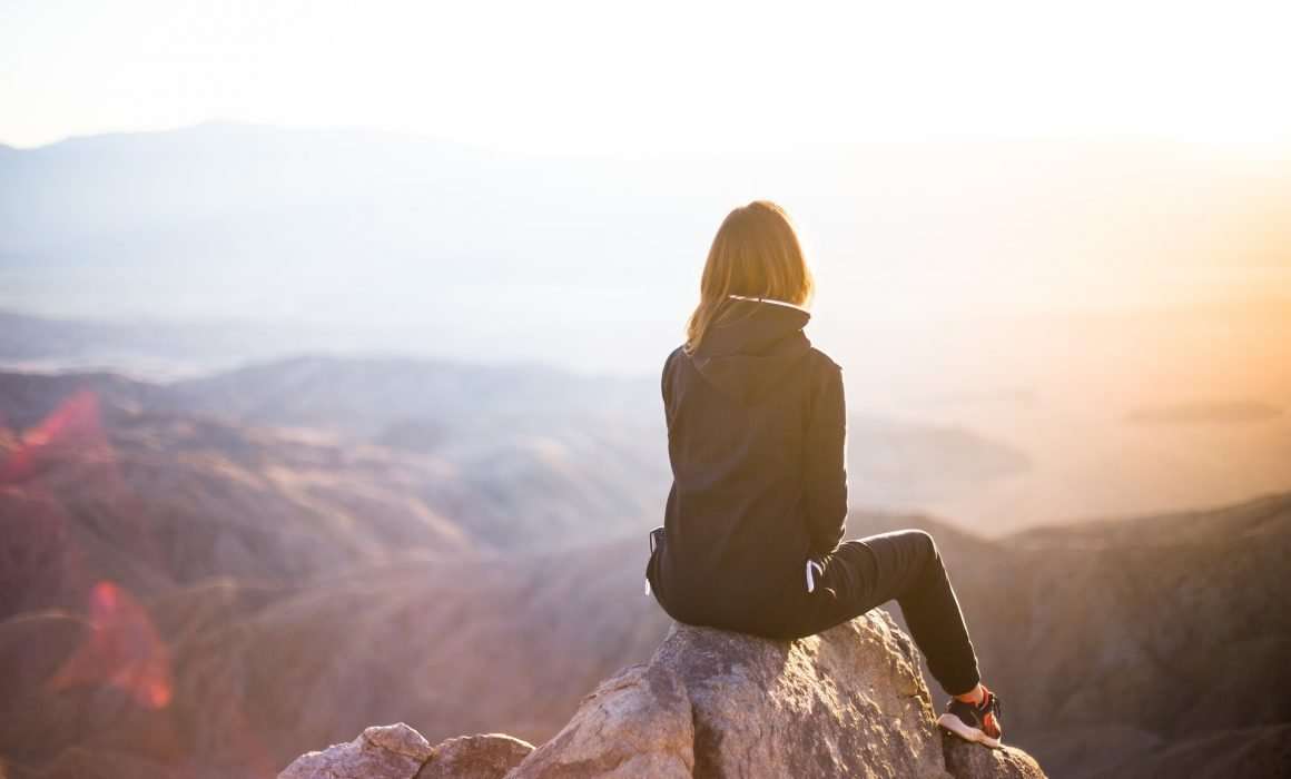 woman-on-rock-high-over-mountains