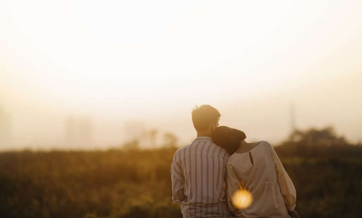 Couple-sitting-together-from-behind-at-dusk