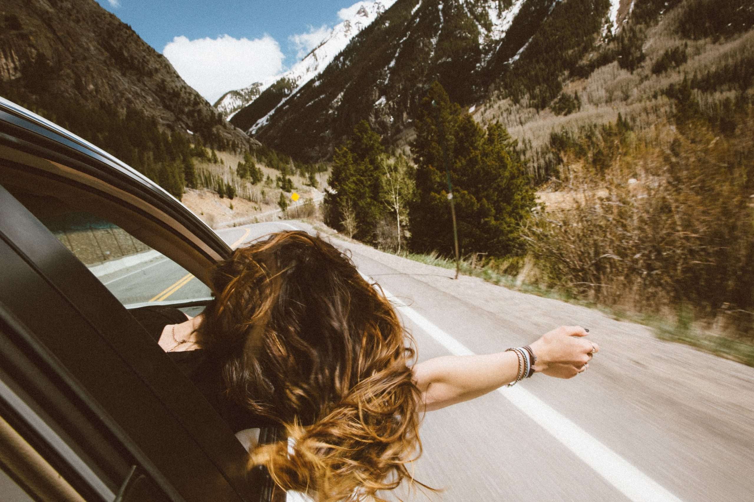 women-leaning-out-of-car-window