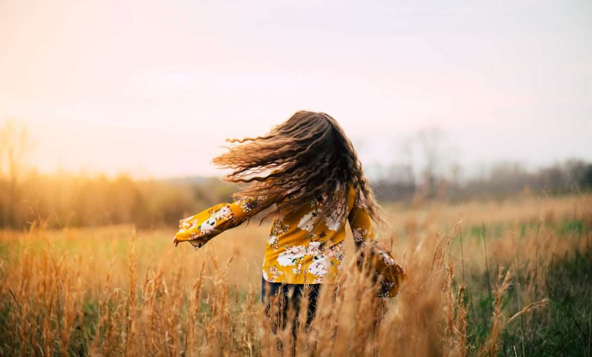 young-girl-spinning-free-in-field
