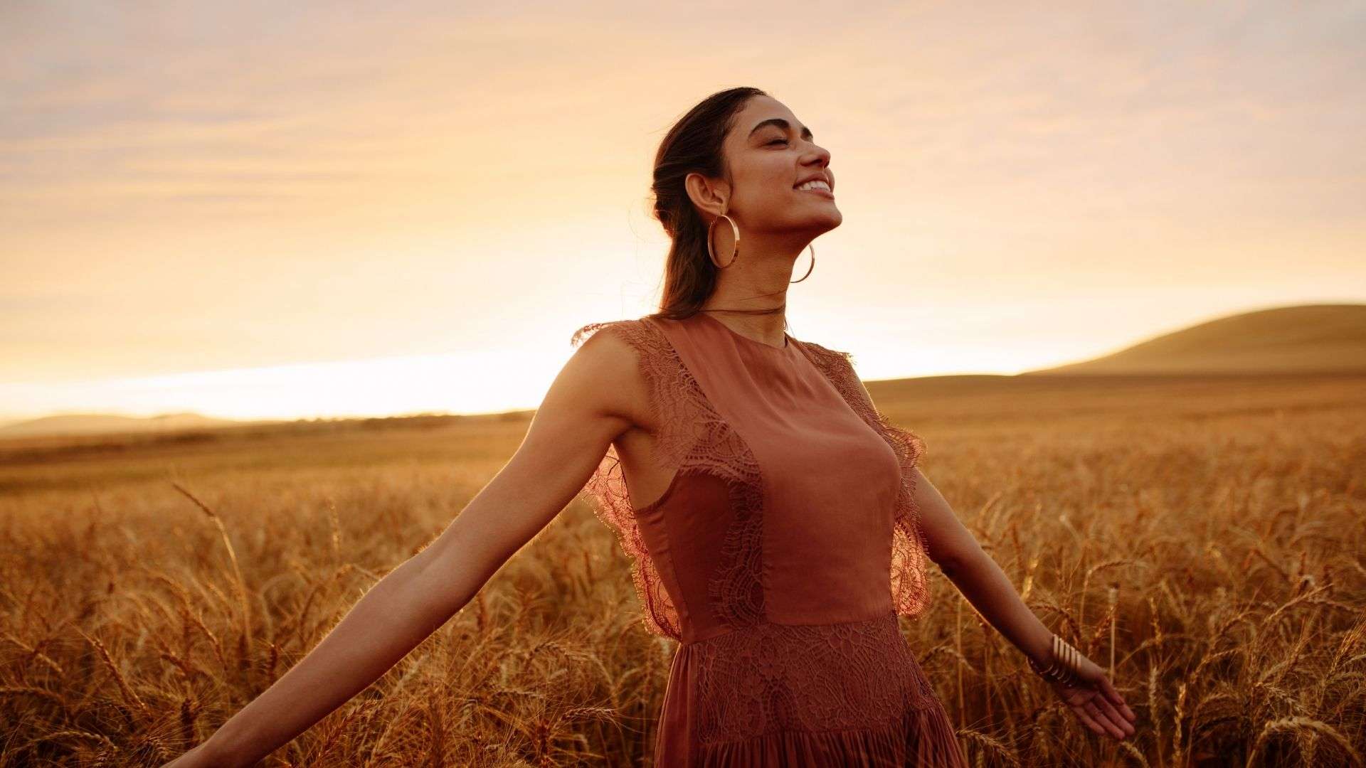 woman-standing-among-wheat-field-at-sunset-eco-friendly-brands-blog-post