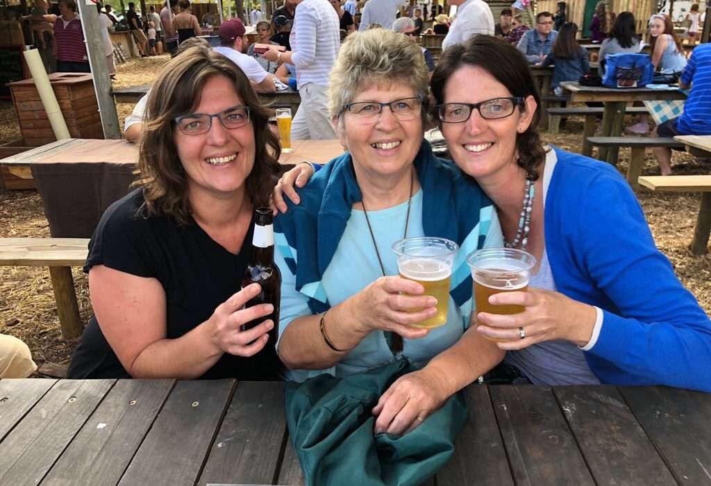 mother-and-two-daughters-picnic-table-toasting-a-drink-mothers-day