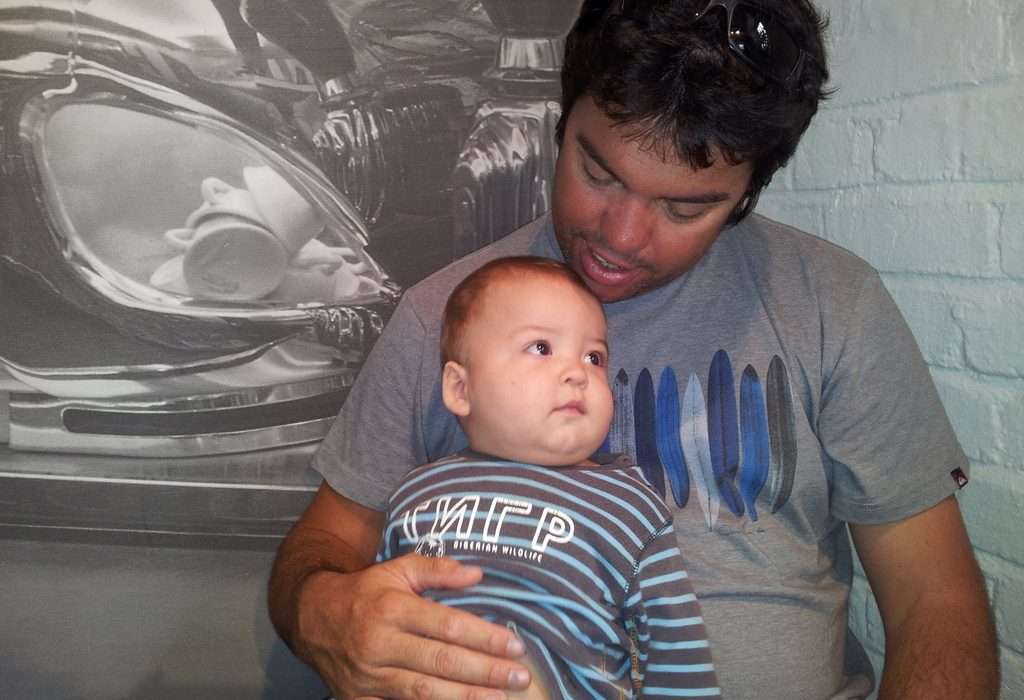 chubby-baby-striped-blue-shirt-sitting-on-fathers-lap