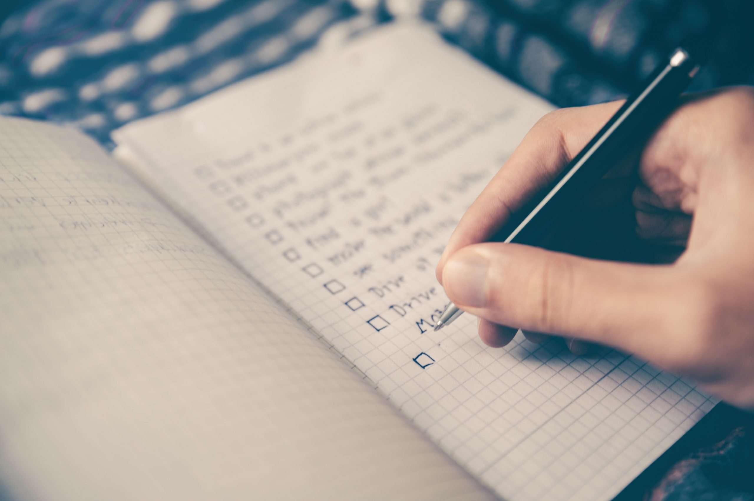 notebook-bucket-list-hand-ticking-off-boxes-on-list
