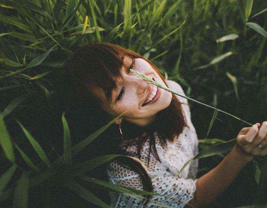 woman-in-tall-grass-smiling-face-to-sun-life-decisions-blog