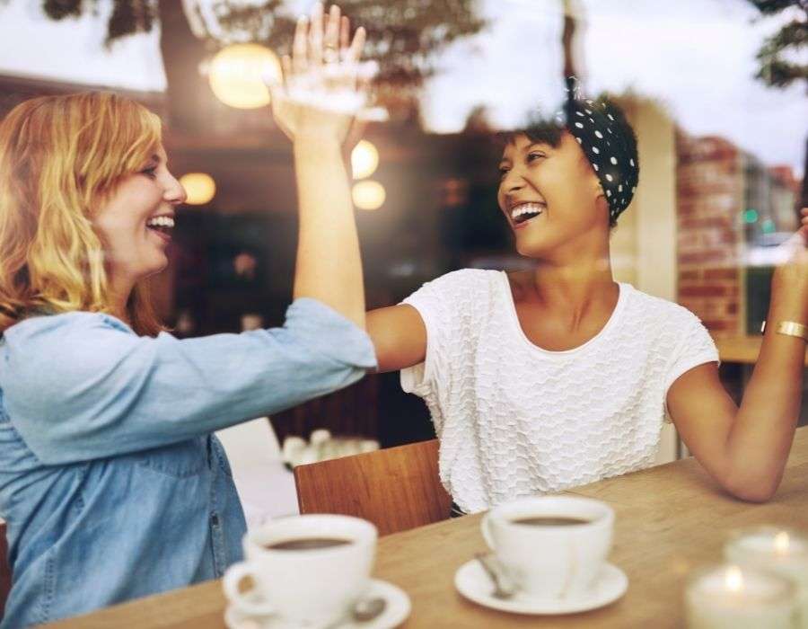 two-woman-high-fiving-smiling-giving-back-brings-joy