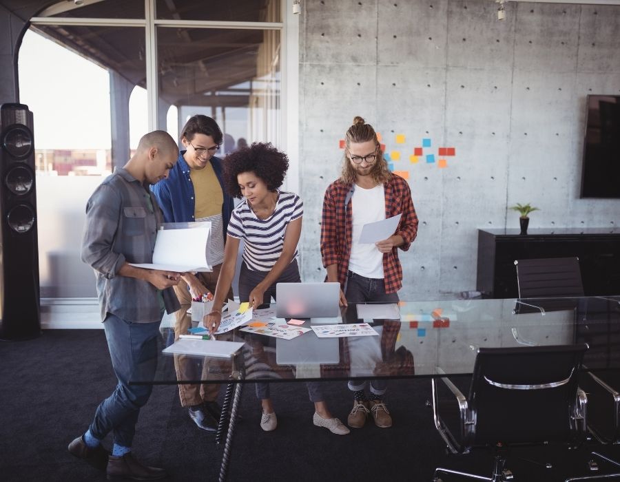 four-work-colleagues-brainstorming-around-boardroom-table-casual-wear