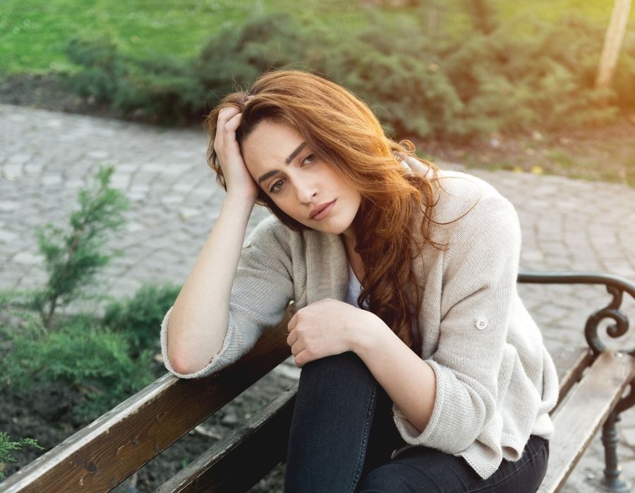 woman-dark-hair-on-park-bench-hand-on-head-overthinking-get-out-of-your-head-blog-post