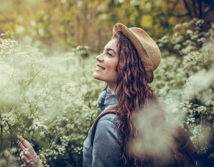 woman-long-dark-hair-straw-hat-standing-among-white-flowers-smiling-creative-expression-and-your-soul-blog-post