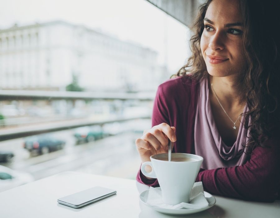 woman-stirring-coffee-smiling-contemplative-intuition-blog-post