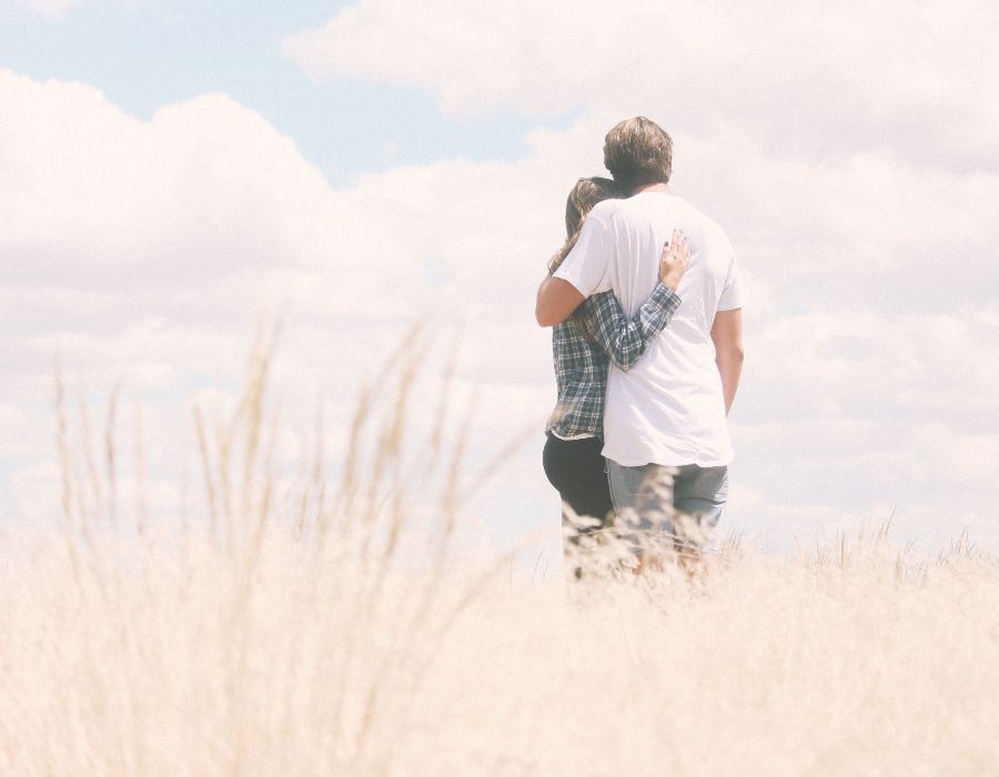 couple-from-behind-in-field-hugging-love-is-the-answer-blog-post