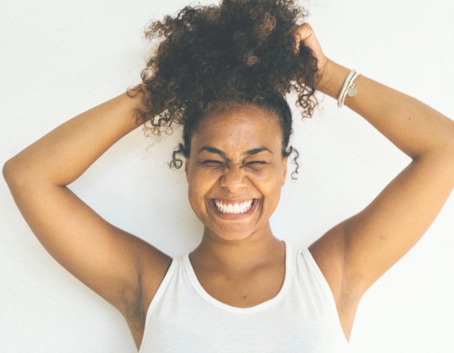 smiling-woman-holding-ponytail-above-head-self-belief-blog