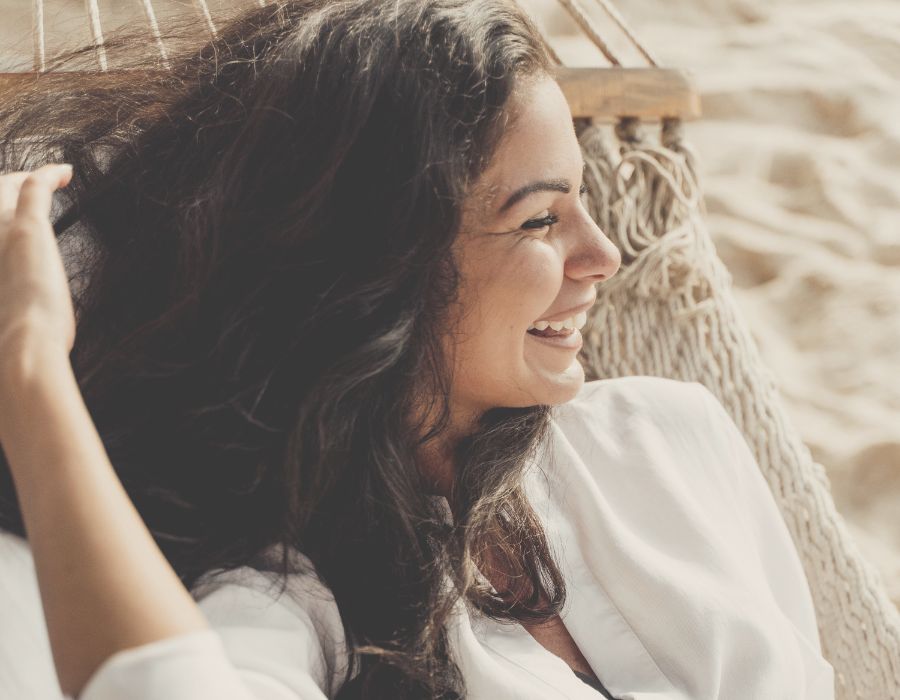 brunette-woman-smiling-in-hammock-on-beach-be-authentic