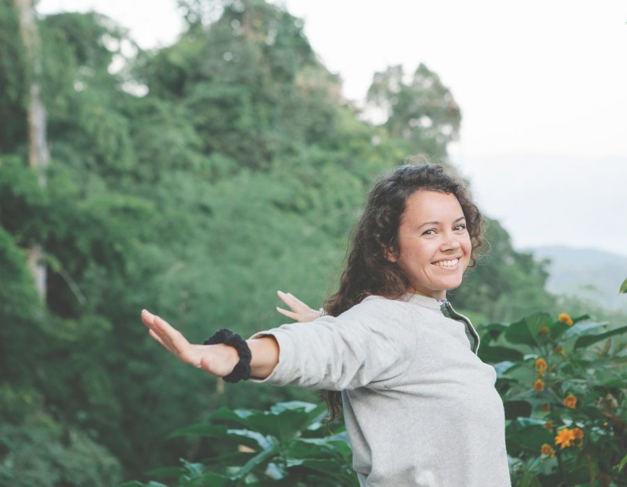 woman-green-mountainside-smiling-arms-outstretched-how-to-be-authentic-blog