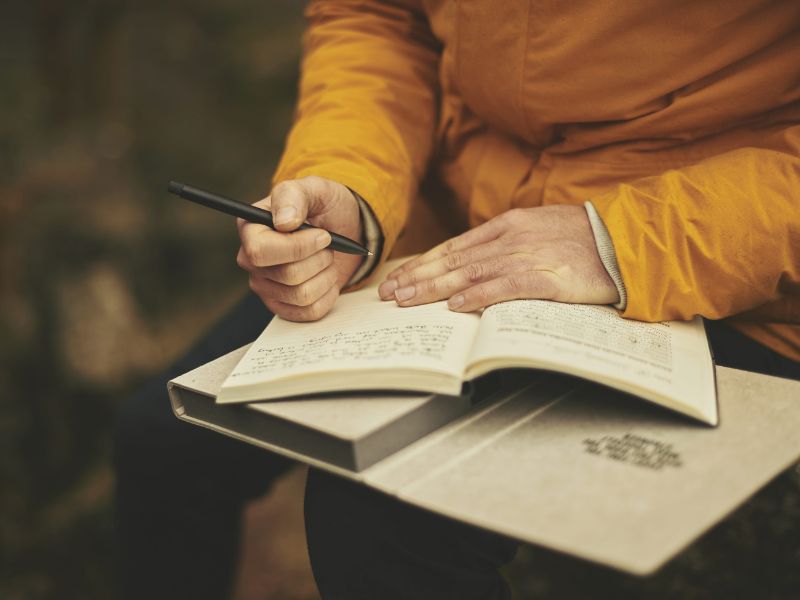 close-up-writing-in-journal-mustard-jumper-book-on-lap-future-self-journalinng-blog